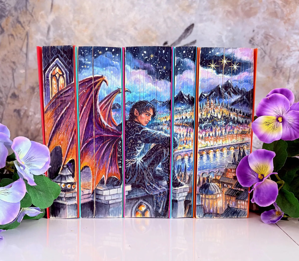ACOTAR : jaspage artisanal, personnage ailé au-dessus d'une ville illuminée